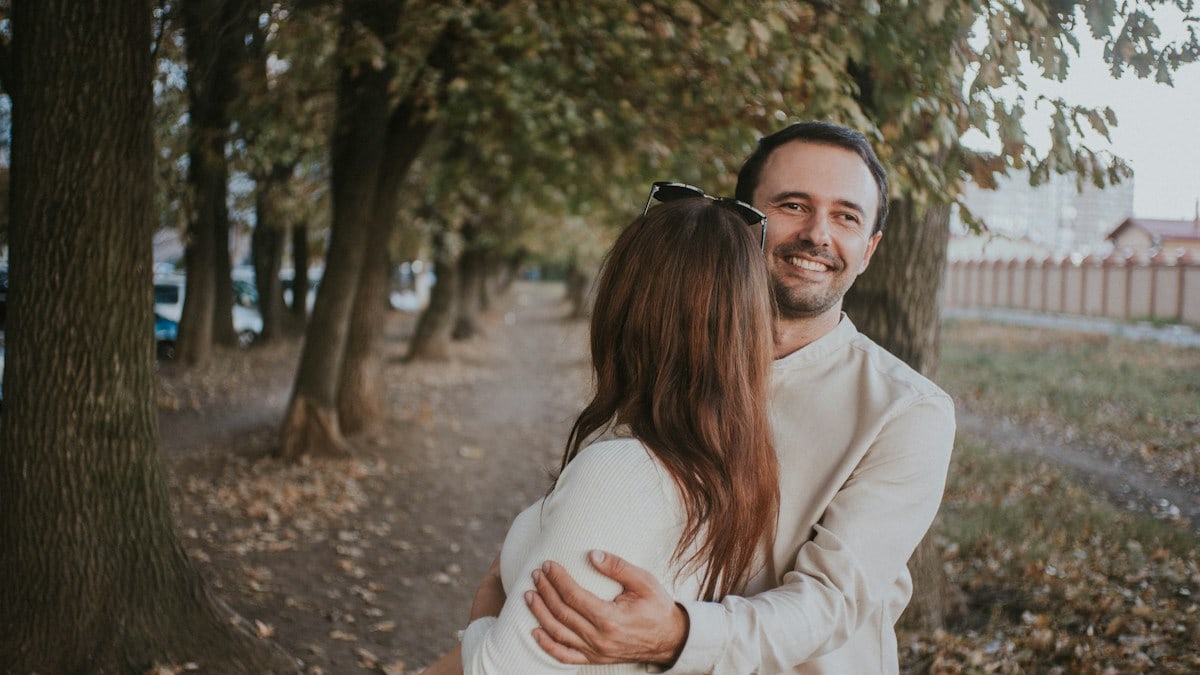 a man holding a woman in his arms in a park